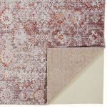 Close-up of Armant Pink / Gray Rug pattern with corner flipped showing beige non-slip rug pad backing