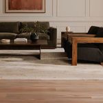 Side view of Rue Nook sectional paired with wooden armchairs on beige rug in elegant room setting