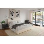 Atelier nightstand styled within a modern bedroom next to a bed with neutral bedding and artwork