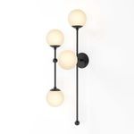 Armstrong 4 L Sconce lit against a clean white wall showcasing the warm glow of the four matte globes