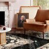 Angle view of rug under armchair and small white side table with glass on top