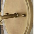 Close-up of antique brass oval wall plate showing smooth finish and small round fasteners