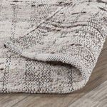 Partial fold of rug showing backside weaving and thickness of wool fibers