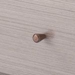 Close-up detail of antique bronze tapered drawer knob on taupe gray oak