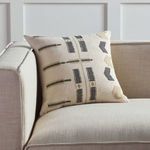 Pillow styled on beige fabric sofa showcasing size and room context