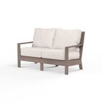Laguna Loveseat outdoor sofa with hand-brushed aluminum frame mimicking driftwood, featuring white cushions