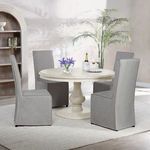 Dining table shown in room setting with four gray upholstered chairs and decorative plants
