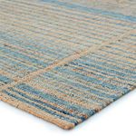 close-up of rug edge showing woven jute and wool fibers in brown and blue stripes