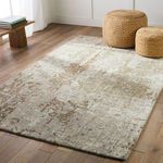 Rug displayed in a light-filled room with wood flooring and woven poufs styled on top