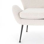 Detailed view of curved chair armrest with visible black metal leg underneath