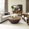 Living room scene with sectional sofa, round wood coffee table, and wood armchair with leather cushions