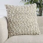 Kaz pillow arranged with neutral furniture, showing woolen loops and soft texture