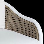 Detailed view of natural cane armrest pattern beneath plush white cushion