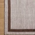 Direct overhead close-up of Easton rug border on light hardwood floor showing weave detail