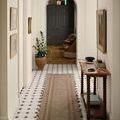 Runner version of Scottie rug in hallway with white walls and wooden console table