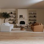 Coffee table in modern living room setting with sofa and fireplace in background