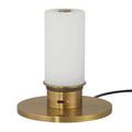 Close-up of cordless lamp base with white light on gold charging plate and LED indicator