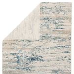 Celil Abstract Ivory/Blue Rug partially folded to reveal the solid ivory underside