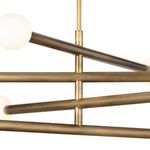 Close-up of the brass arms intersecting with visible texture and smooth globe light covers