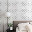 Bedroom wall covered in Mitchell Black Fleur Premium Matte Wallpaper showing side view with bed, pillows, nightstand, and ...