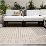 rug placed outdoors under white cushioned sectional sofa with decorative pillows