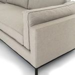 Detailed close-up of sofa armrest and seat cushion seams in light beige fabric