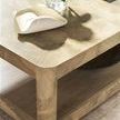 Close-up of Verge Cocktail Table corner showing curved edges and natural wood texture with decorative items on top