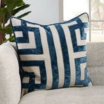 Pillow styled on light beige sofa with natural light and greenery in background
