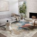 Spirit Stone rug laid in modern living room with gray sofa, white side table, fireplace, and natural light