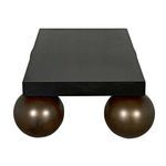 Top view capturing the rectangular matte black steel surface with two brass spheres visible underneath