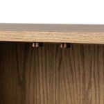 Close-up detail of small metal latches on the base of one interior shelf inside the sideboard