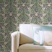 Wallpaper applied behind cream sofa with decorative blue and beige pillows in cozy living room setting