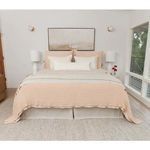 Front view of Vancouver Coverlet styled on bed in bright bedroom with lamps and wall art