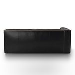 Back view of black left-facing sectional showcasing full leather panel and stitched seams