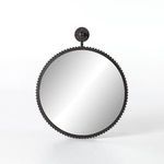 Front view of round black framed mirror with geometric ridged detailing on frame and mount