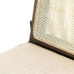 Close-up detail of natural cane meeting cream fabric seat cushion