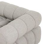 Close-up of tufted backrest and armrest corner showcasing fabric texture and stitching