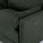 Knife-edge pillow resting against welted arm with textured sage leather