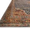 Close-up of Layla rug corner on wood floor, showing detailed border pattern and low pile texture