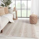 Gray and brown spotted animal print rug styled in living room with sofa, pillows, pouf, and large window
