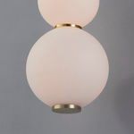Close-up of two frosted white glass globes with brass hardware connectors