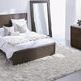 Pawn accent table styled as bedside table in modern bedroom setting with dark wood furniture and light rug