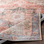Corner of rug lifted to reveal backing and stitched edge details