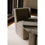Dining chair angled near round marble table in room with white rug and hardwood floor