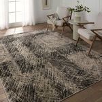 Rug styled in a living room setting with modern wood chairs and soft natural light