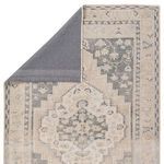 Rug partially flipped to reveal dark gray non-slip backing and front pattern details