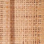 Close-up of tightly woven natural raffia texture showing detailed weaving pattern on mirror frame