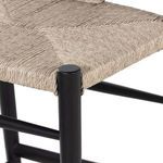 Close-up of curved black teak armrest and woven seat joint