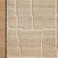 Close-up of Asha Natural Rug corner on wooden floor highlighting raised textured geometric pattern