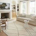 Fabian rug styled in bright living room with sofa, fireplace, and cream curtains